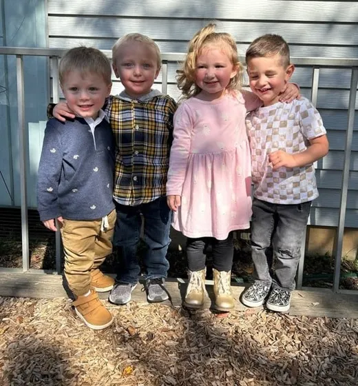 Four young friends standing together outside